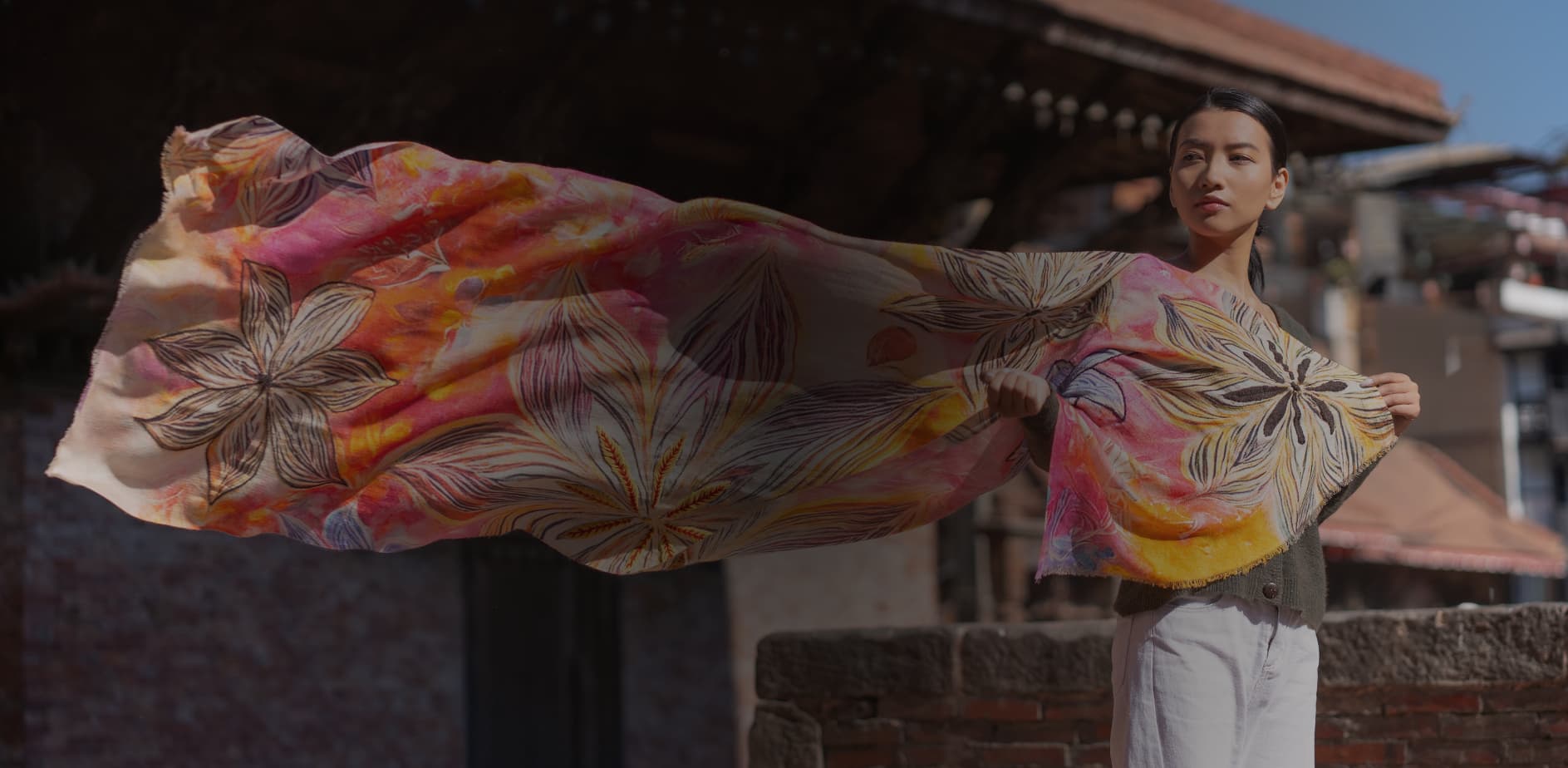 Handwoven Himalayan cashmere scarf draped over a wooden pillar